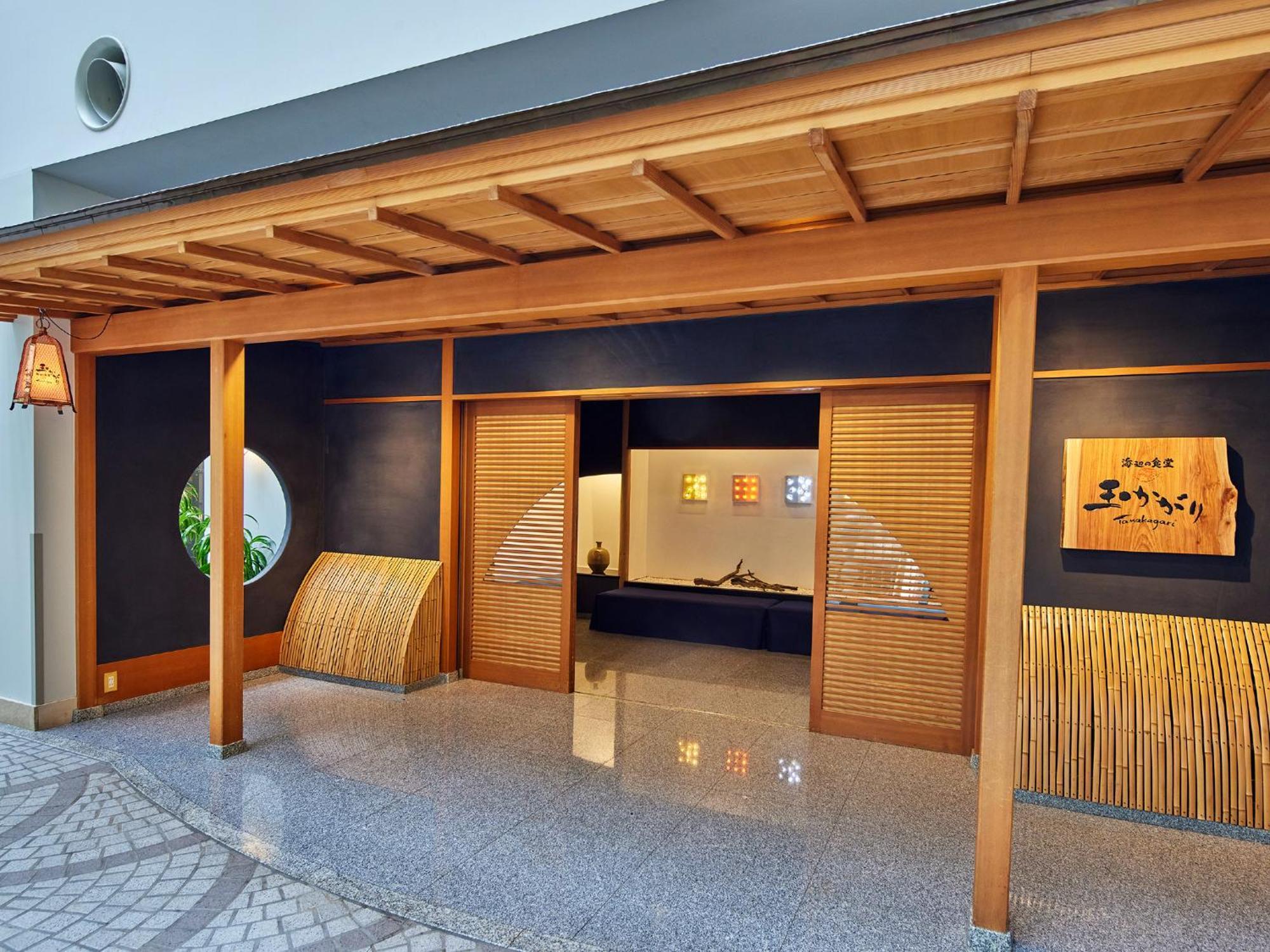 Grand Nikko Tokyo Bay Maihama Hotel Urayasu Екстериор снимка The photo shows the entrance of a building, designed in a traditional Japanese style. It features a wooden structure with a large overhanging roof and sliding doors. The entrance is flanked by rounded windows, and there's a decorative sign with Japan