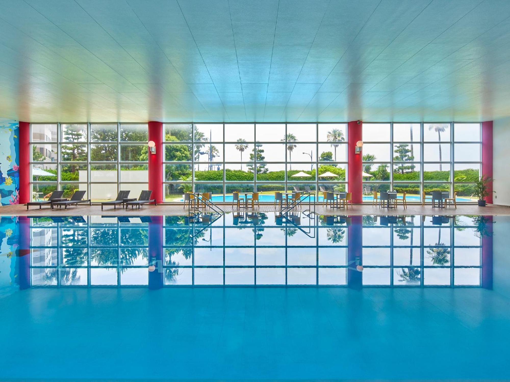 Grand Nikko Tokyo Bay Maihama Hotel Urayasu Екстериор снимка The photo shows an indoor swimming pool with bright blue water. The pool area is spacious, characterized by large windows that allow natural light to flood in, creating a vibrant atmosphere. The walls are painted in a soft color, with accents of red.